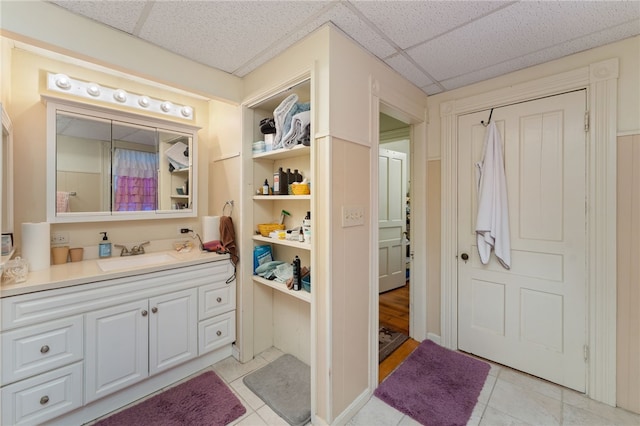 bathroom featuring a paneled ceiling, vanity, and tile patterned floors