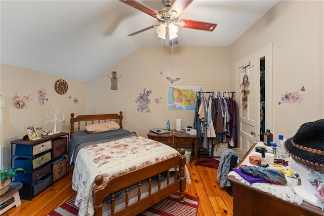 bedroom featuring a ceiling fan, light wood-type flooring, and lofted ceiling