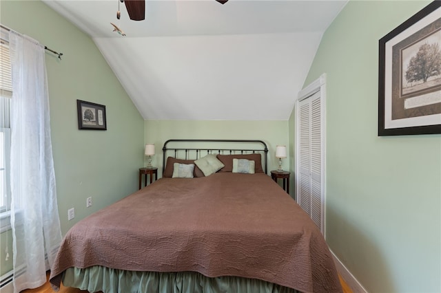 bedroom featuring ceiling fan, a baseboard heating unit, baseboards, vaulted ceiling, and a closet