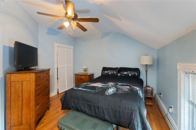 bedroom with lofted ceiling, ceiling fan, light wood finished floors, and baseboard heating