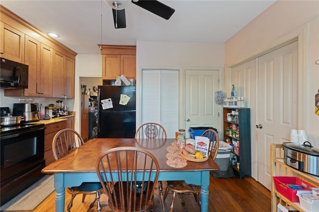 kitchen with ceiling fan, dark wood-style flooring, light countertops, brown cabinets, and black appliances