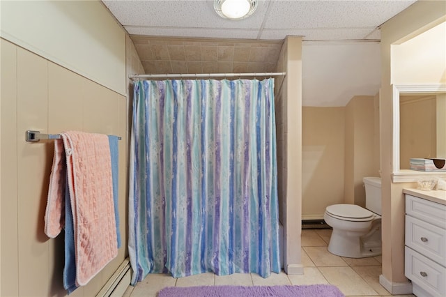 bathroom with a drop ceiling, tile patterned flooring, toilet, vanity, and a shower with curtain