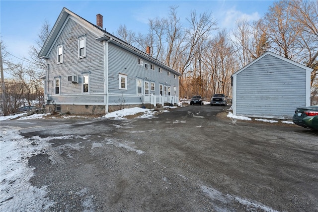 view of snowy exterior with a chimney