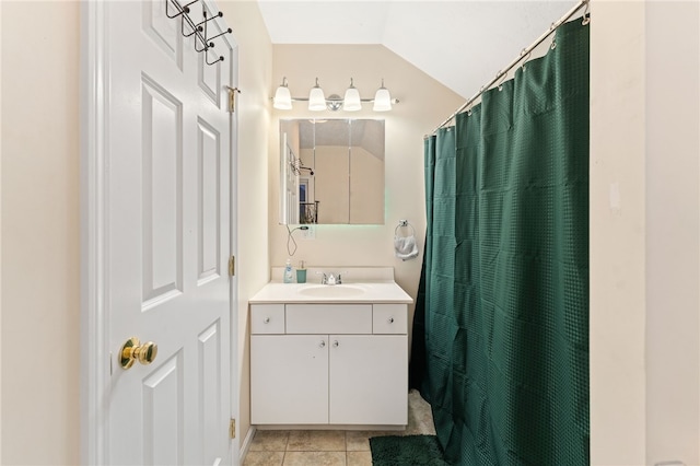 bathroom with vaulted ceiling, a shower with curtain, vanity, and tile patterned floors