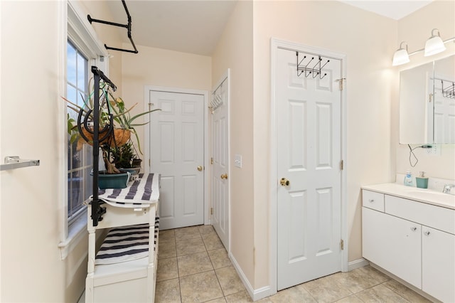 bathroom with tile patterned flooring, vanity, and baseboards