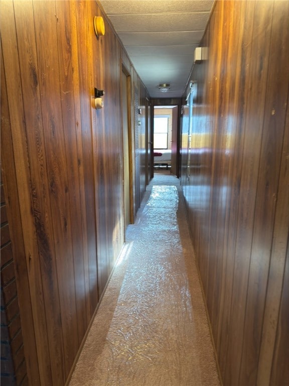 corridor featuring wooden walls