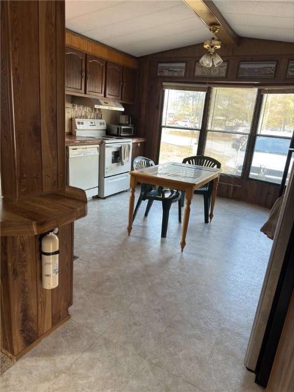 unfurnished dining area with lofted ceiling with beams, light floors, and wood walls