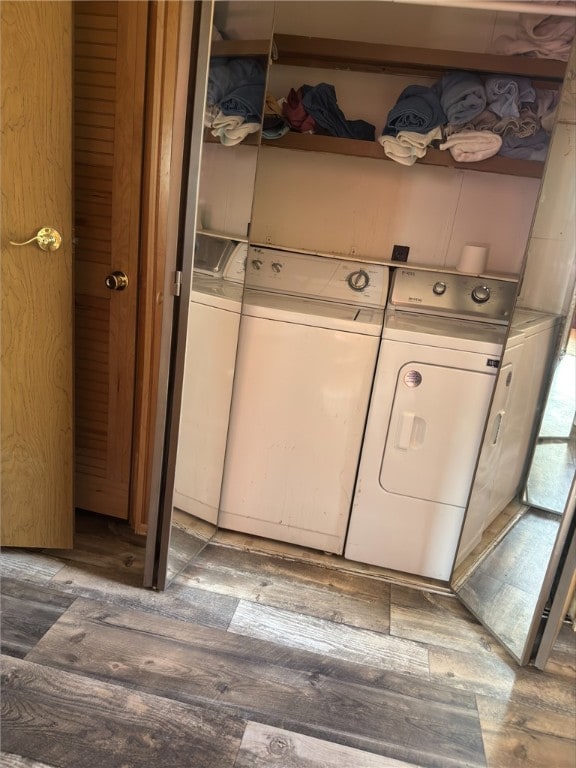 clothes washing area featuring laundry area, washer and clothes dryer, and wood finished floors