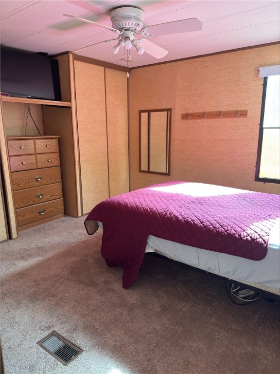 unfurnished bedroom featuring ceiling fan, visible vents, and carpet flooring