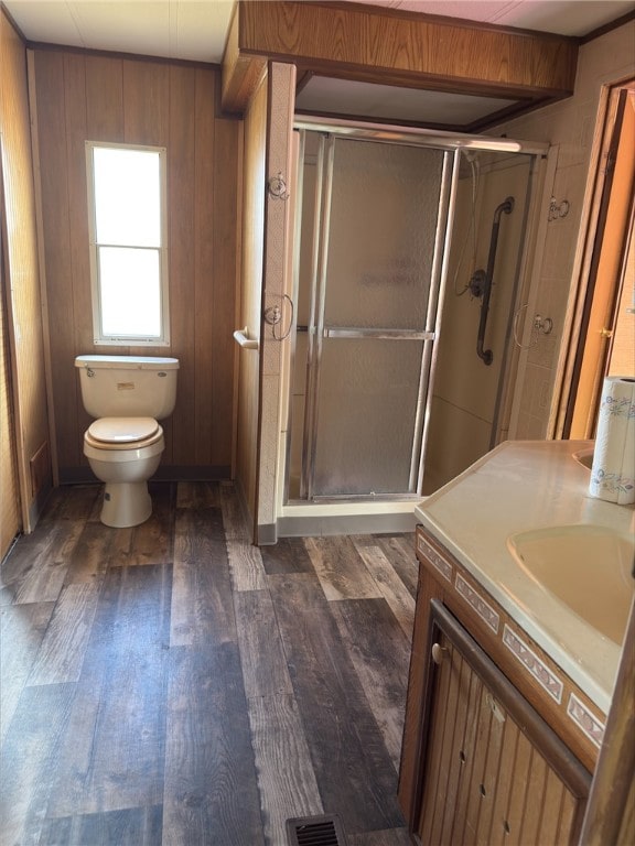 full bath with a stall shower, vanity, toilet, and wood finished floors