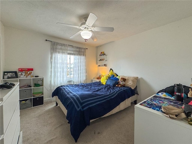 carpeted bedroom featuring a textured ceiling and a ceiling fan