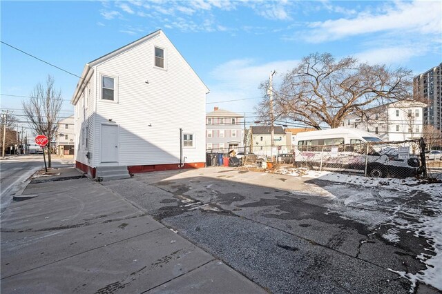 exterior space featuring entry steps, fence, and a residential view