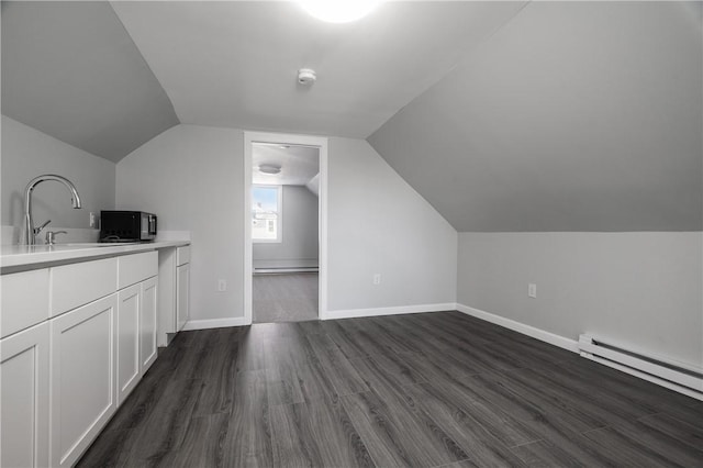 bonus room featuring lofted ceiling, dark wood-style floors, baseboards, and a baseboard heating unit