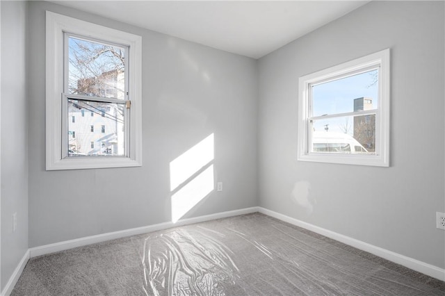 carpeted spare room with baseboards