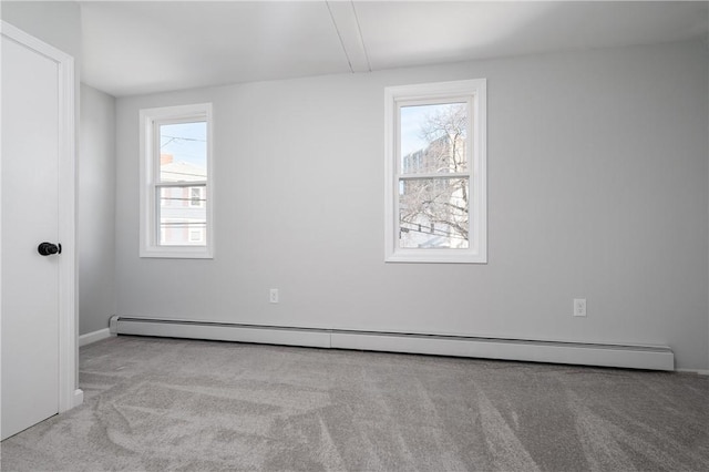 carpeted empty room with a baseboard heating unit