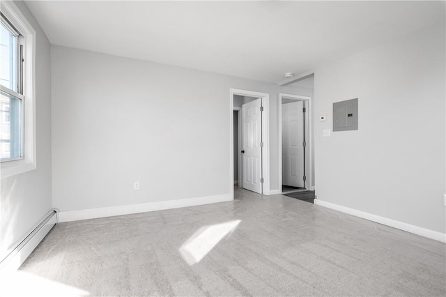 unfurnished bedroom with a baseboard heating unit, carpet flooring, electric panel, and baseboards