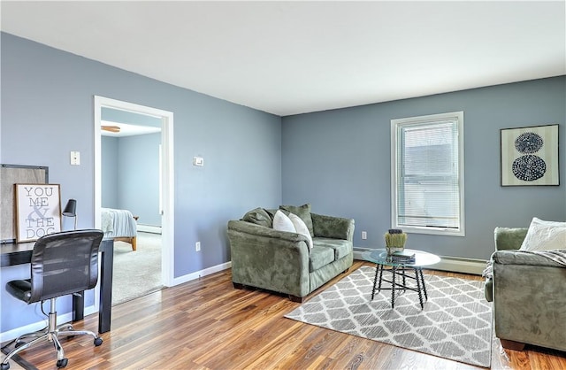 living room with a baseboard radiator, baseboards, and wood finished floors