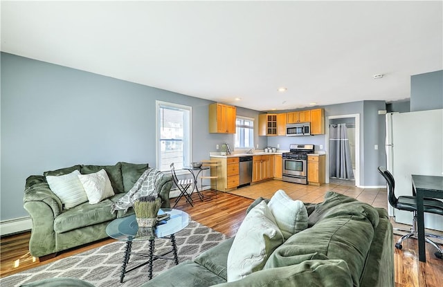 living room featuring light wood-style floors, baseboards, and recessed lighting