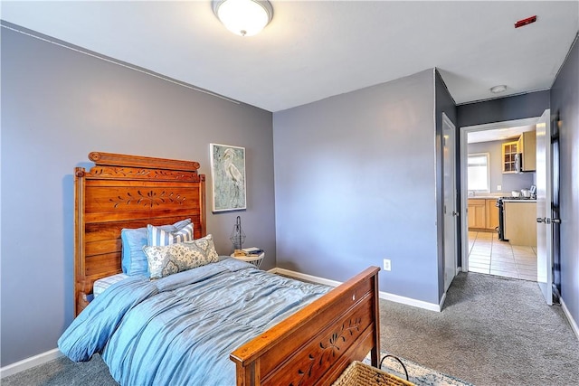 bedroom featuring light carpet and baseboards