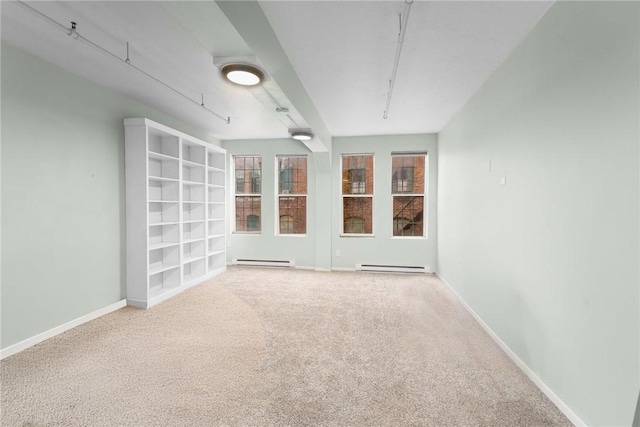 carpeted spare room featuring a baseboard radiator and baseboards