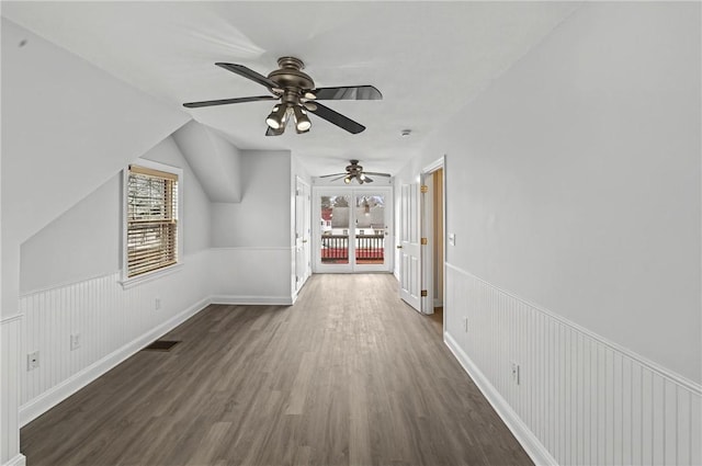 bonus room featuring plenty of natural light, wood finished floors, and wainscoting