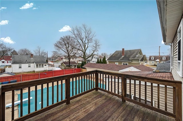 wooden deck with a fenced backyard, a residential view, and a fenced in pool