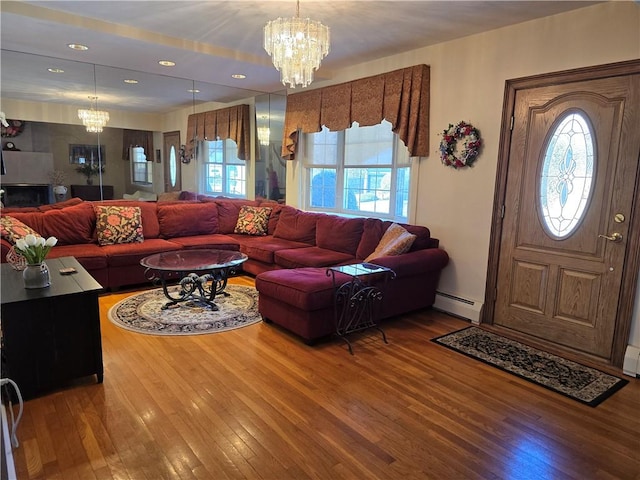 living room featuring a chandelier, a baseboard heating unit, hardwood / wood-style flooring, and recessed lighting