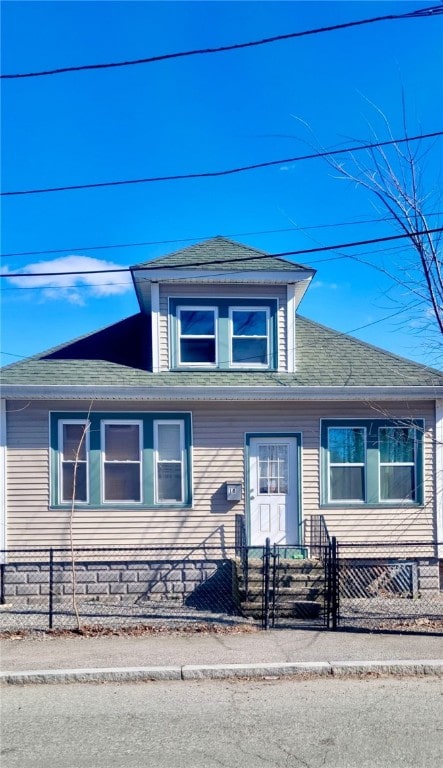 view of front of home featuring a fenced front yard and a shingled roof