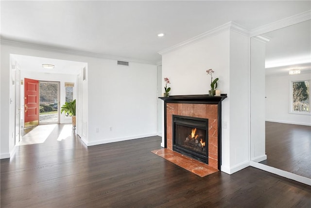 unfurnished living room with ornamental molding, a tiled fireplace, wood finished floors, and baseboards