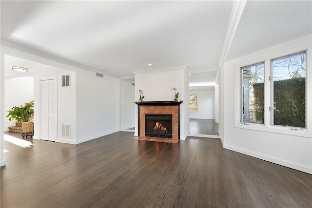 unfurnished living room featuring dark wood-type flooring, crown molding, and a tiled fireplace