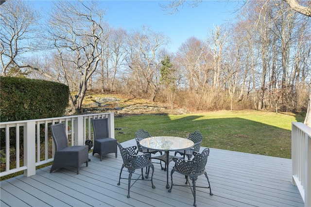 deck featuring outdoor dining space and a yard