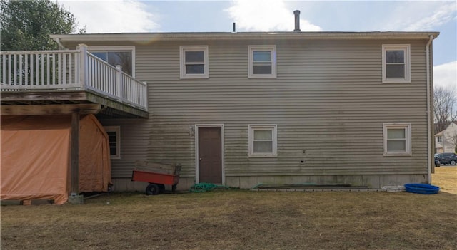 rear view of house with a deck and a yard