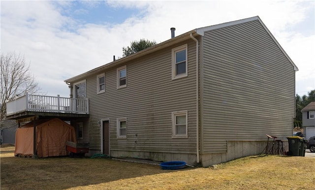 view of side of property with a storage unit, a lawn, a deck, and an outdoor structure