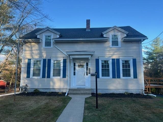 view of front of home featuring a chimney and a front yard