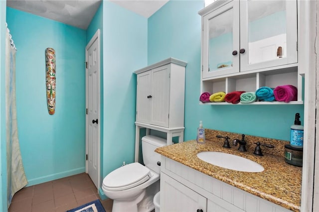 bathroom featuring baseboards, toilet, vanity, and tile patterned flooring