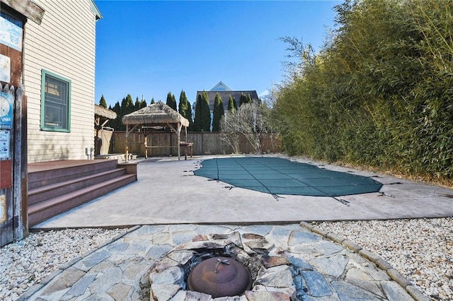 view of swimming pool featuring a fenced in pool, fence, an outdoor fire pit, a gazebo, and a patio area