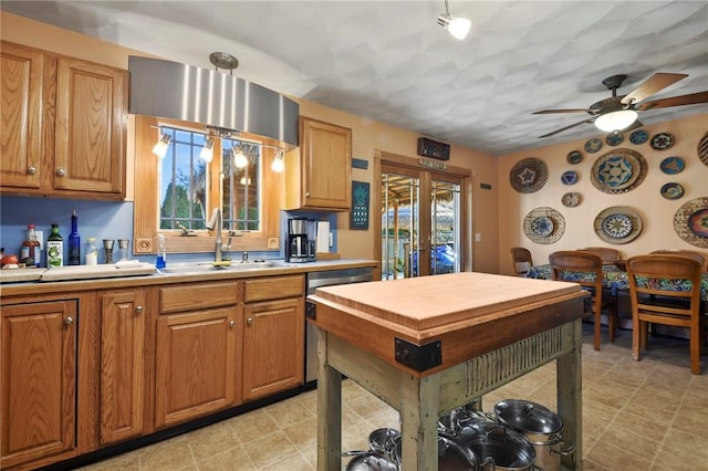 kitchen with a ceiling fan, a sink, stainless steel dishwasher, french doors, and brown cabinetry