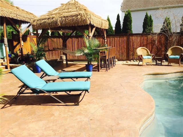 view of swimming pool featuring a gazebo, a fenced backyard, and a patio