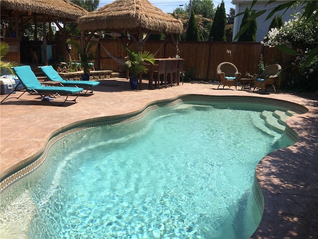 view of pool with a patio, a fenced in pool, a fenced backyard, a gazebo, and outdoor dry bar