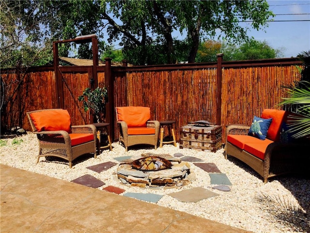 view of patio / terrace featuring an outdoor living space with a fire pit and a fenced backyard