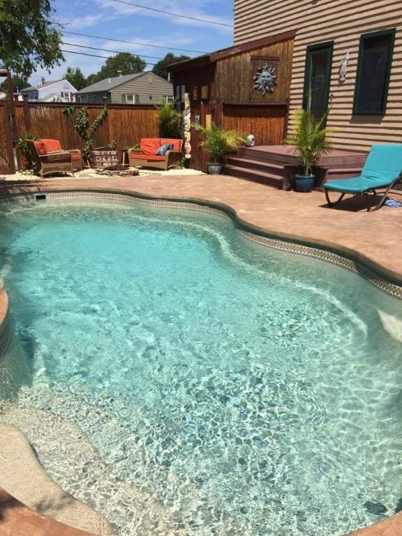 view of swimming pool with a fenced in pool, fence, an outdoor hangout area, a deck, and a patio area