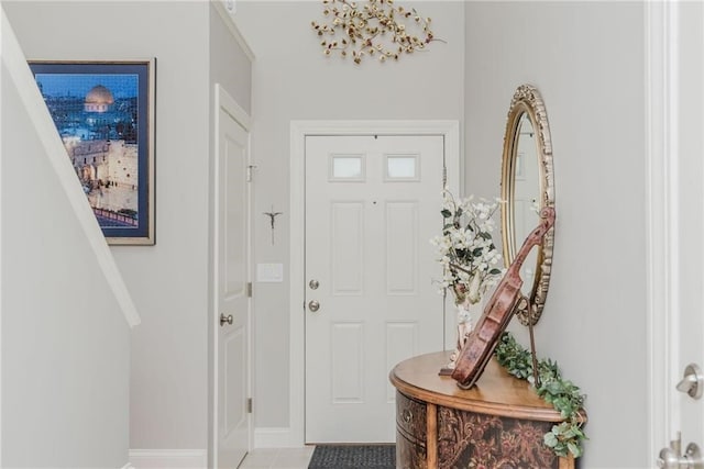 foyer with light tile patterned flooring and baseboards