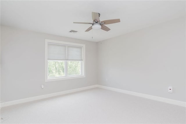 empty room with visible vents, light colored carpet, baseboards, and ceiling fan