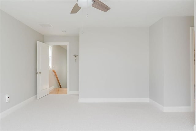 empty room featuring baseboards, carpet floors, and a ceiling fan