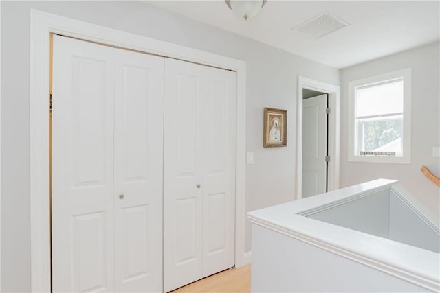 corridor with visible vents and light wood-style flooring