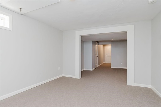 carpeted spare room featuring baseboards