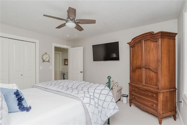 bedroom with a closet, light carpet, and a ceiling fan