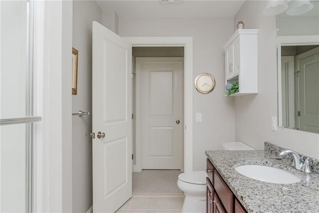 bathroom featuring toilet, vanity, and tile patterned flooring