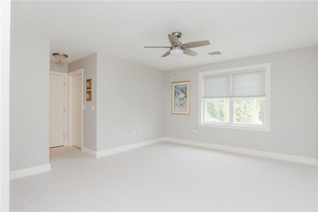 spare room featuring visible vents, baseboards, light colored carpet, and a ceiling fan