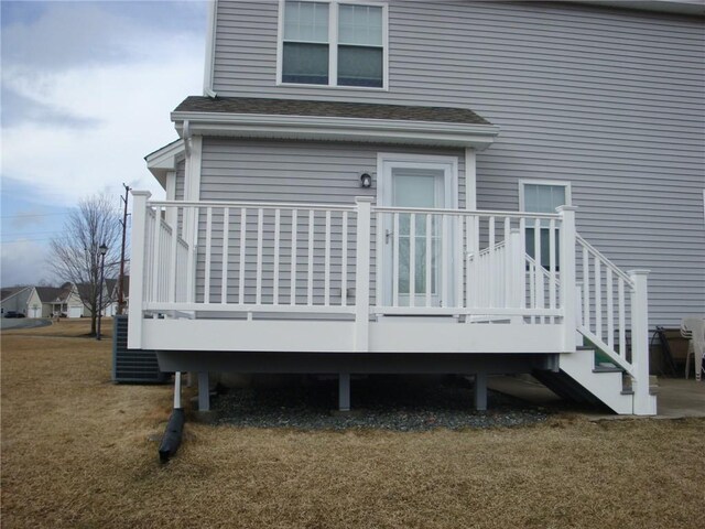 rear view of property featuring cooling unit, a yard, and a shingled roof